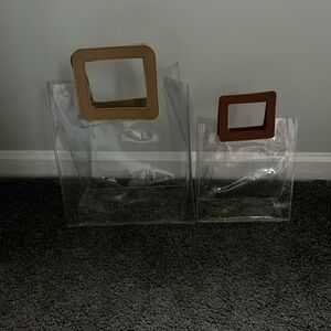 Two Clear handbags with faux leather handles